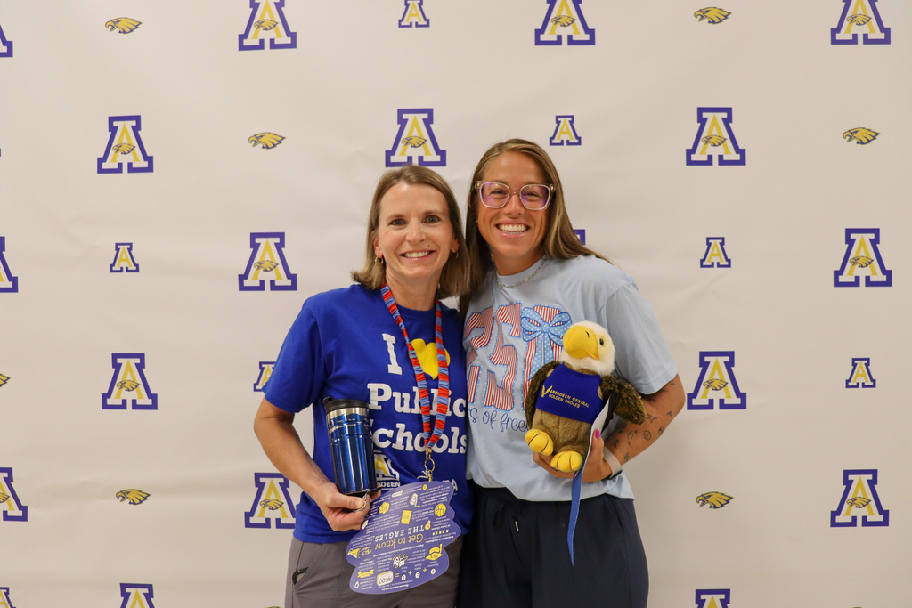 Aberdeen Public Schools teachers smiling and holding a stuffed Eagle