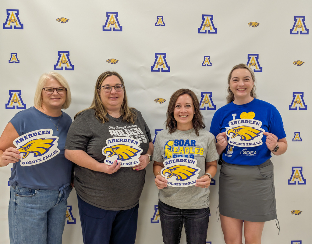 Aberdeen Public Schools teachers smiling and holding Eagles signs