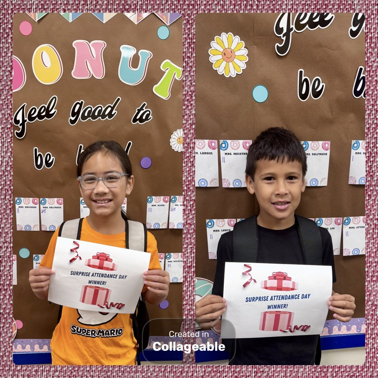Two students standing in front of a bulletin board accepting an attendance award.