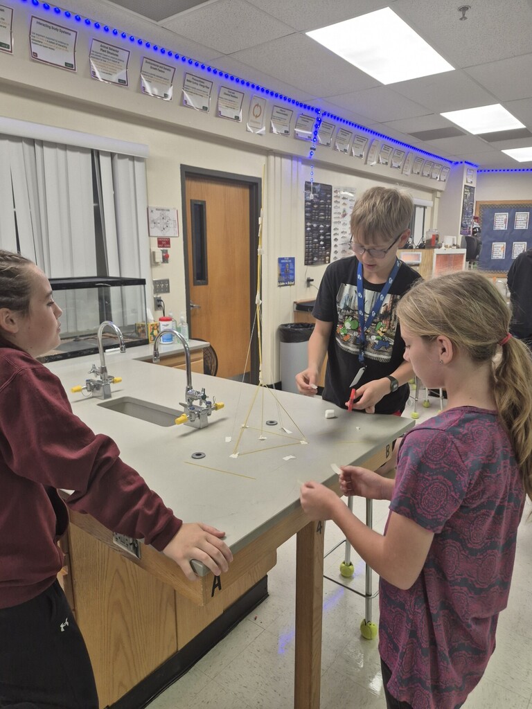 7th grade students using NGSS Science and Engineering Practices to complete the "Marshmallow Challenge" where they needed to build the tallest tower to support a marshmallow using spaghetti, string, and tape.  