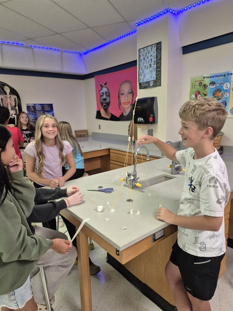 7th grade students using NGSS Science and Engineering Practices to complete the "Marshmallow Challenge" where they needed to build the tallest tower to support a marshmallow using spaghetti, string, and tape.  