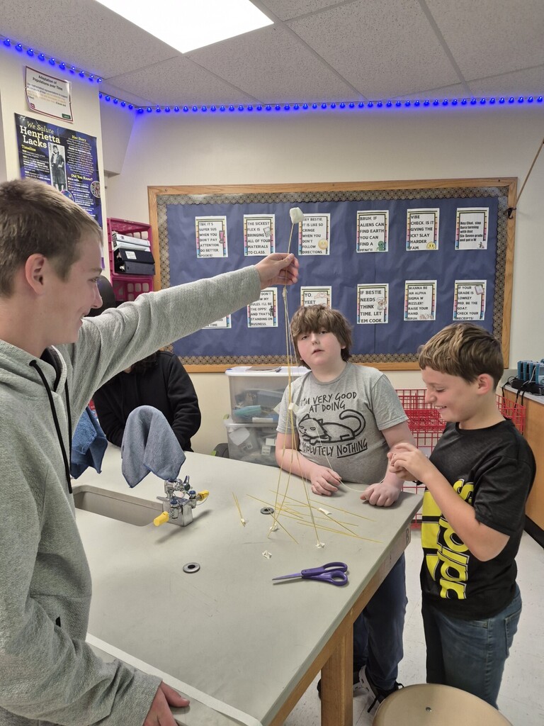 7th grade students using NGSS Science and Engineering Practices to complete the "Marshmallow Challenge" where they needed to build the tallest tower to support a marshmallow using spaghetti, string, and tape.  