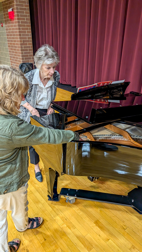 Susan Appl and Sue Gates looking at the inside of the new piano