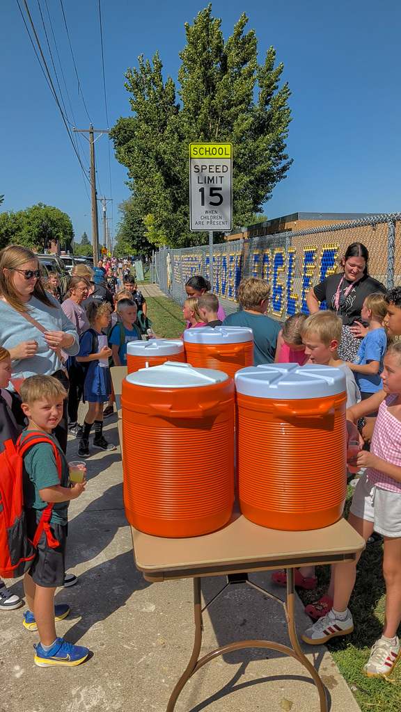 May Overby students and staff running a lemonade stand outside the school