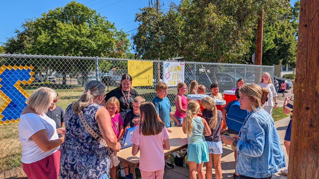 May Overby students and staff running a lemonade stand outside the school