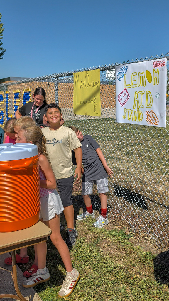 May Overby students and staff running a lemonade stand outside the school
