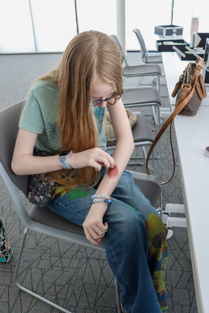 Student participating in the CHS stage makeup workshop at the library