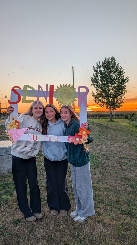 CHS seniors posing with a Senior Sunrise frame with the sunrise in the background