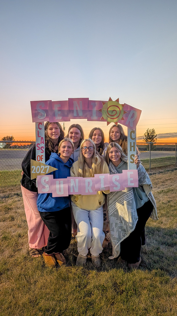 CHS seniors posing with a Senior Sunrise frame with the sunrise in the background