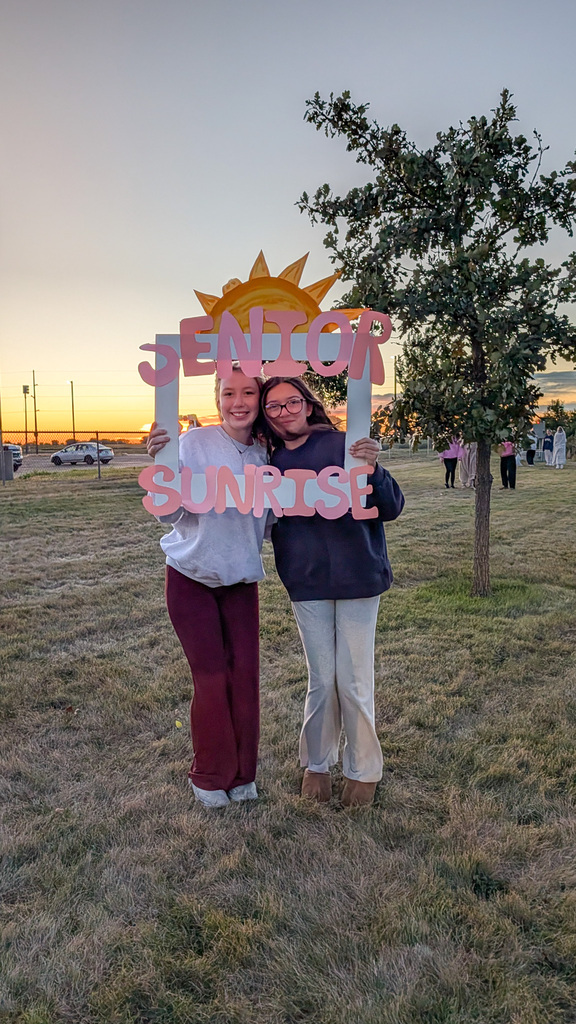 CHS seniors posing with a Senior Sunrise frame with the sunrise in the background