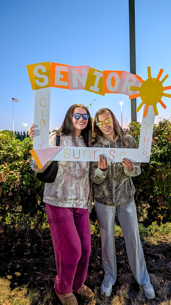 CHS seniors posing with a Senior Sunrise frame wearing class of 2027 sunglasses
