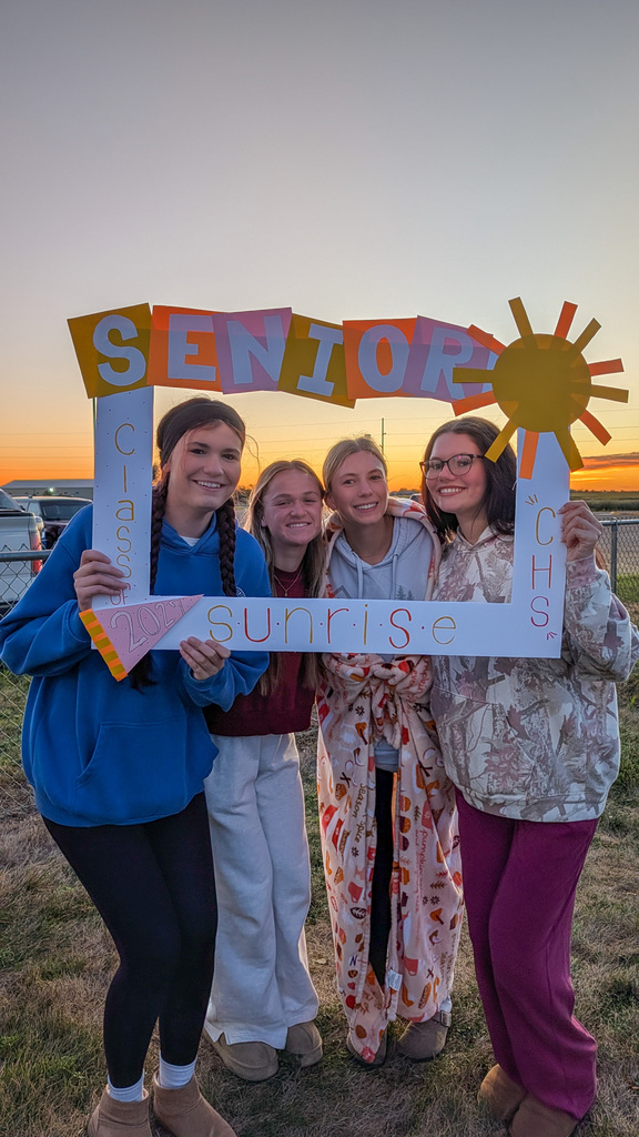 CHS seniors posing with a Senior Sunrise frame with the sunrise in the background