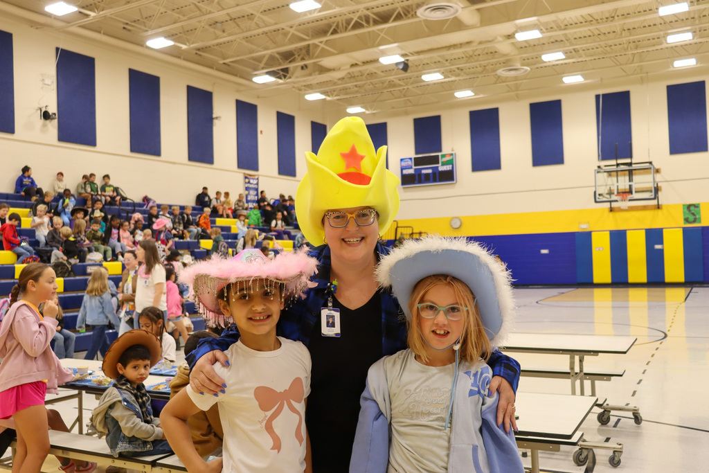 Mrs. Aman and two students wearing cowboy hats