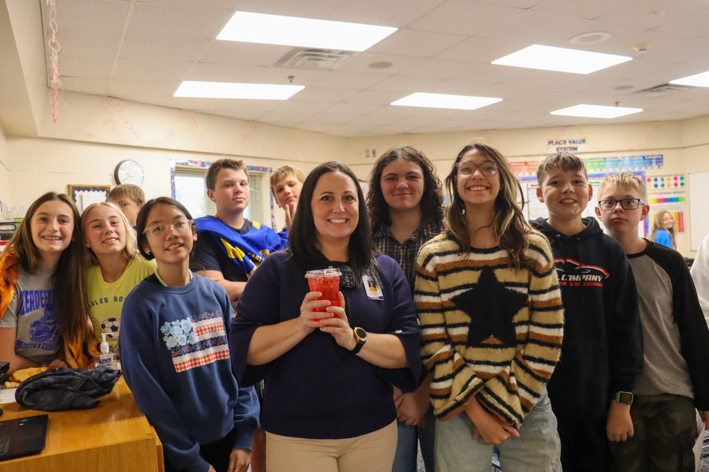 Holgate teacher with her coffee and with students