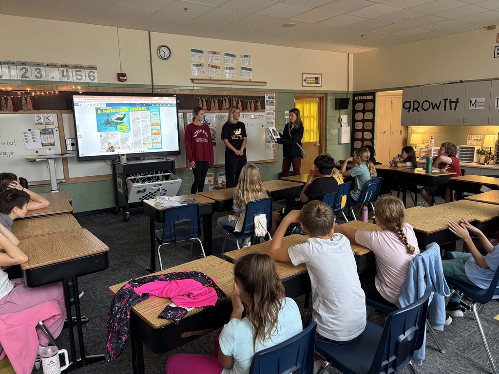 NSU volleyball players reading about perseverance to our class