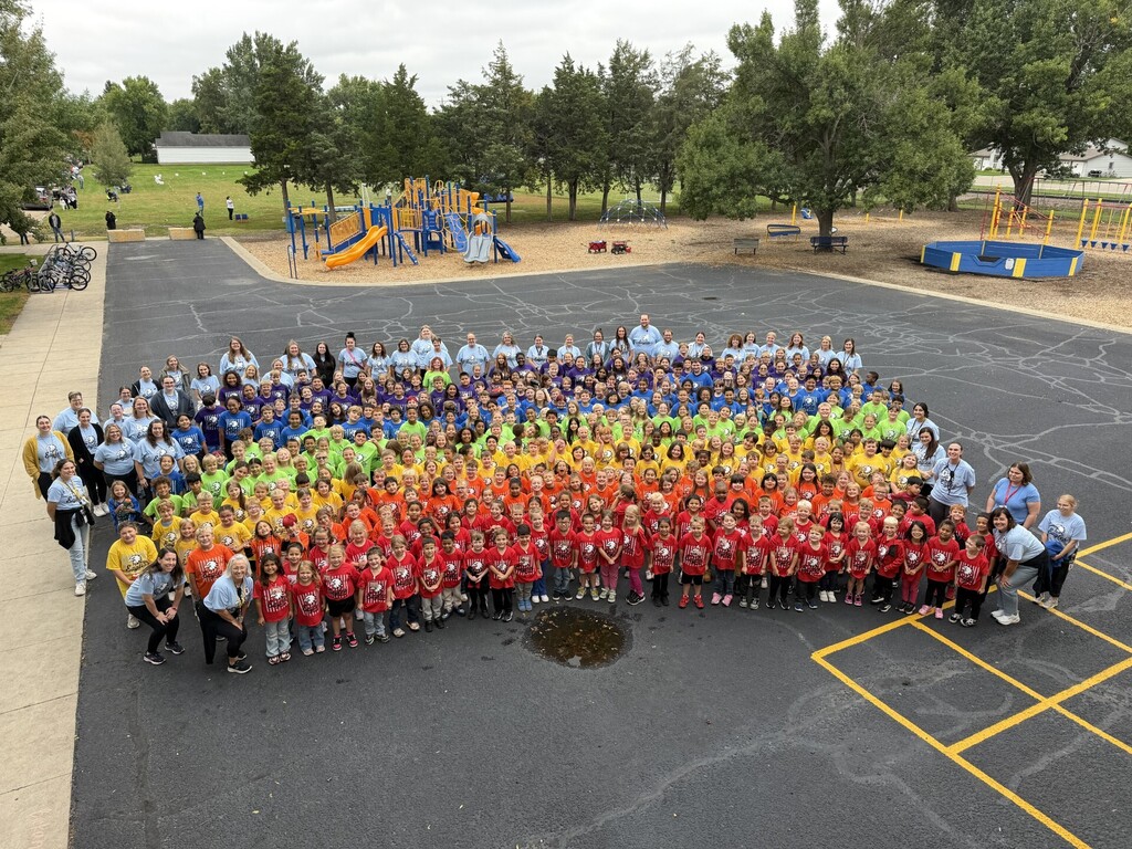  A group photo of Simmons Elementary students and staff in shirts of every color of the rainbow