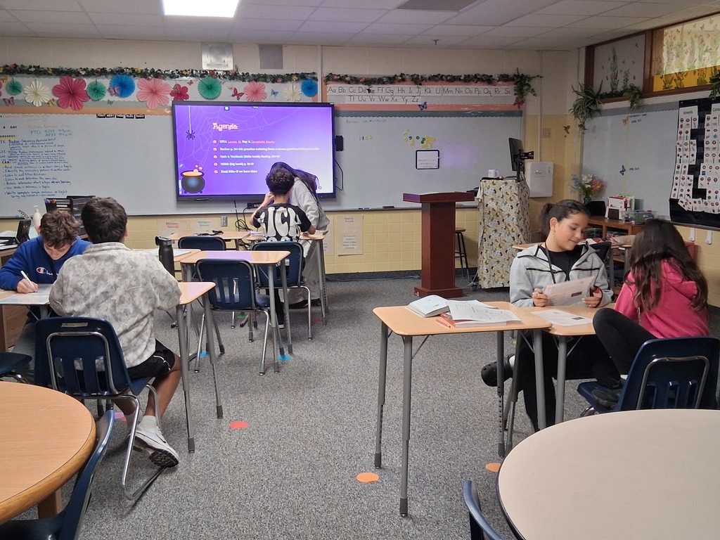 6th grade students working with a partner to practice ordering from a menu and taking an order.