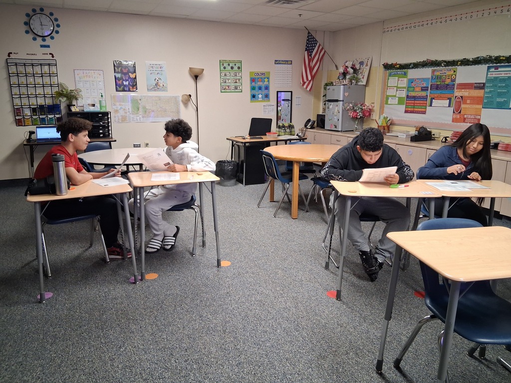 8th grade students working with a partner to practice ordering from a menu and taking an order.