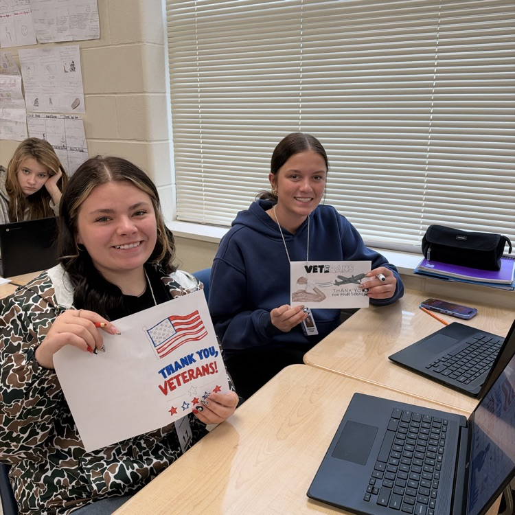 Students working on cards at their desks.
