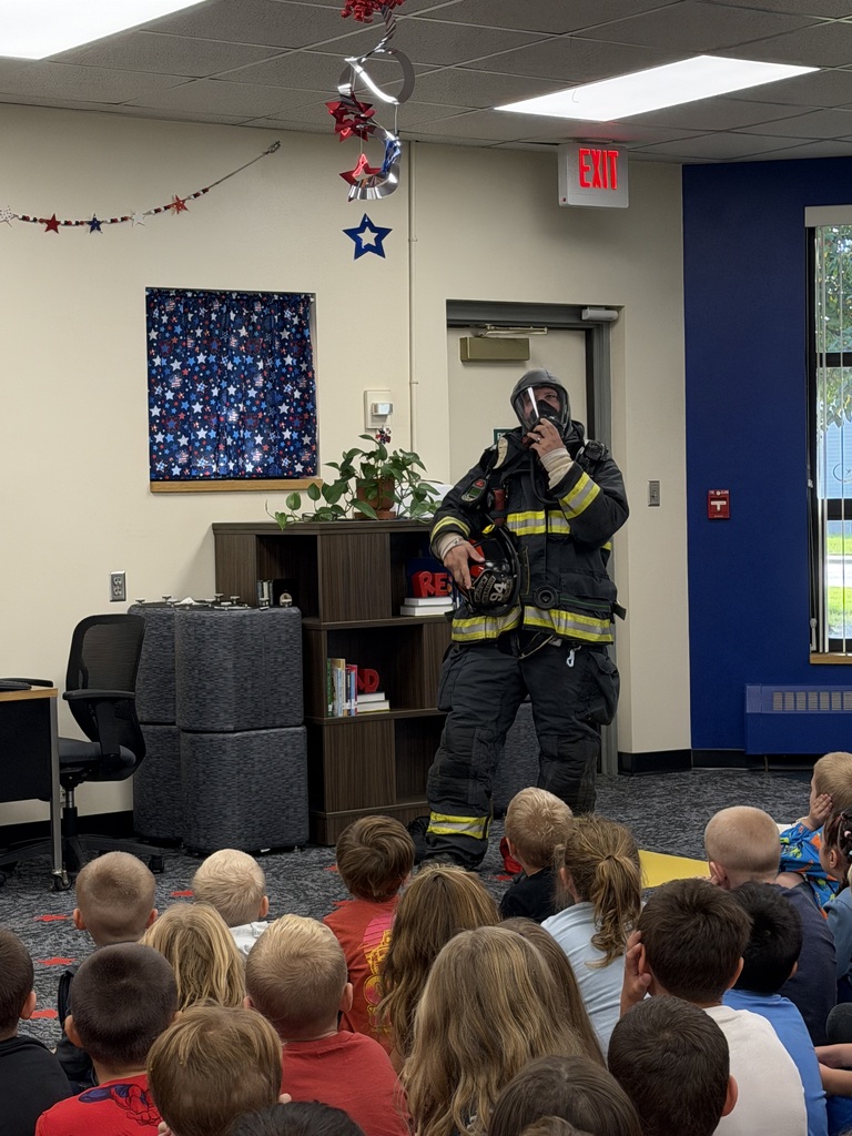 Firefighter showing gear to students.