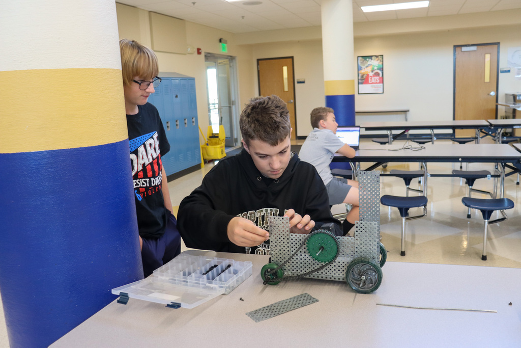 SMS 8th grader working on the car he made in robotics