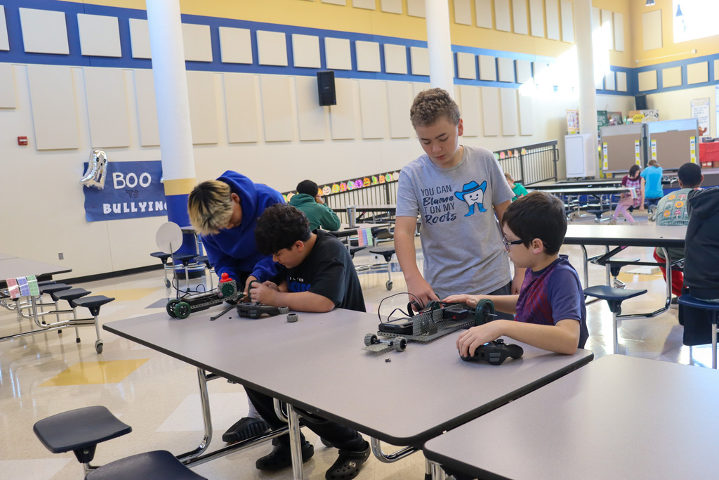SMS 8th graders working on the cars they made in robotics