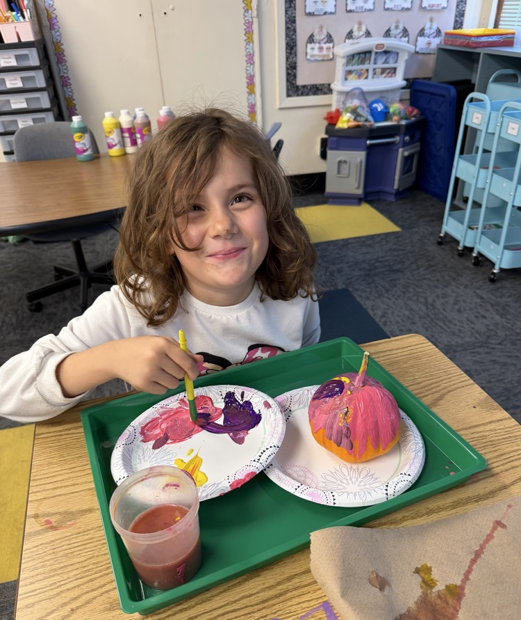 student painting pumpkin