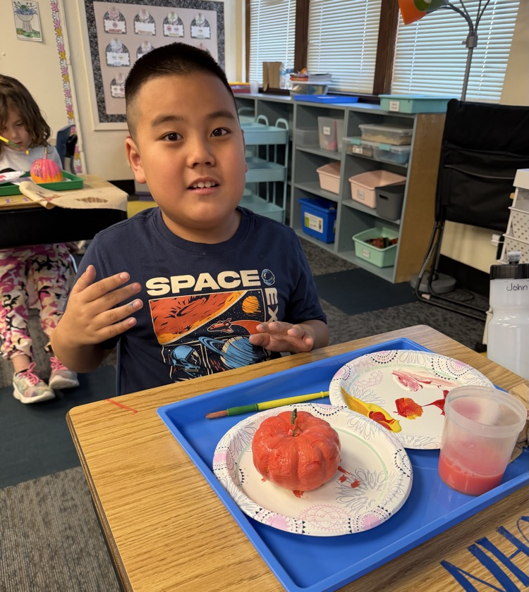 student painting pumpkin