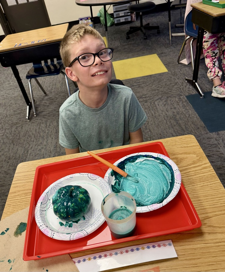 student painting pumpkin