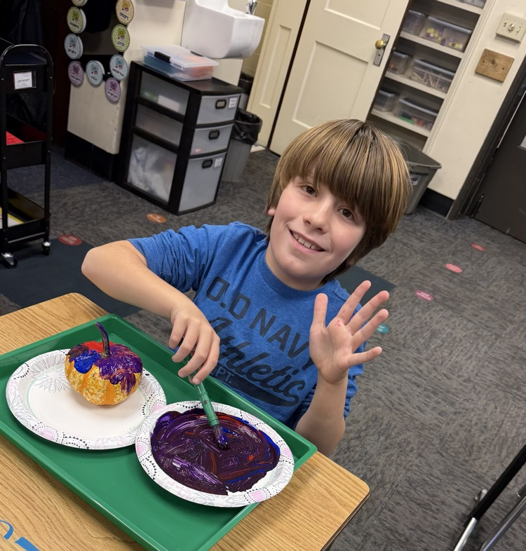 student painting pumpkin