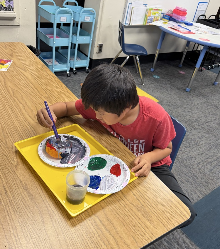 student painting pumpkin