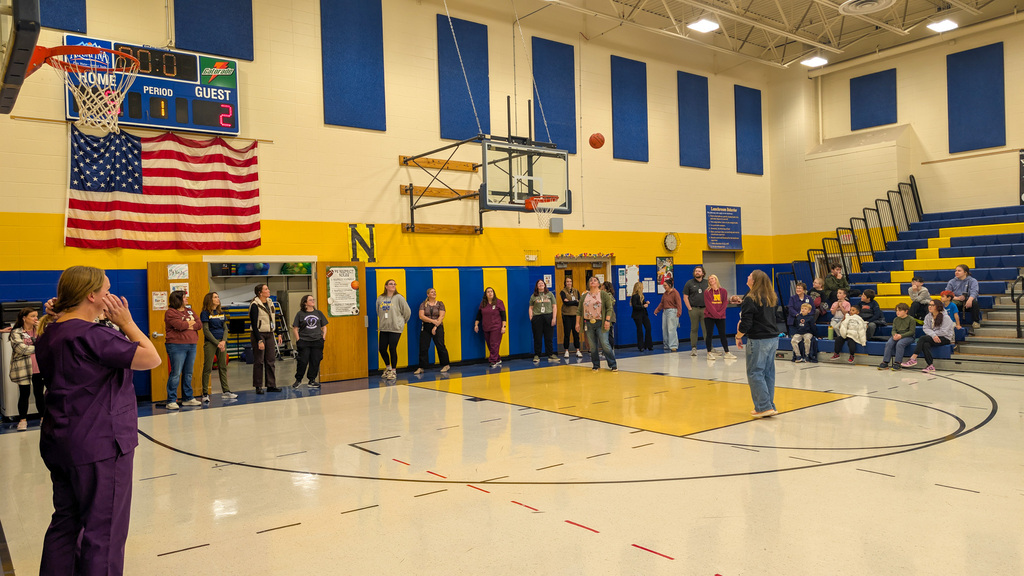 A teacher shooting a basketball during the student-staff free throw contest