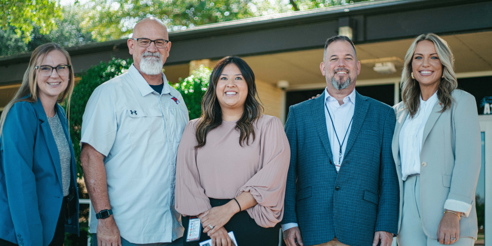 A photo of an employee award winner with her school principal, AISD superintendent, and representative from First Financial Bank