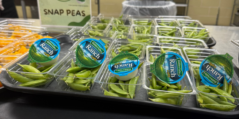 A photo of snap peas with ranch dip