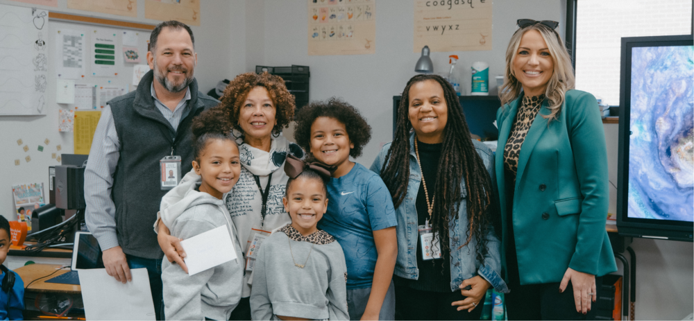 A photo of an employee award winner with her grandchildren, school principal, AISD superintendent, and representative from First Financial Bank