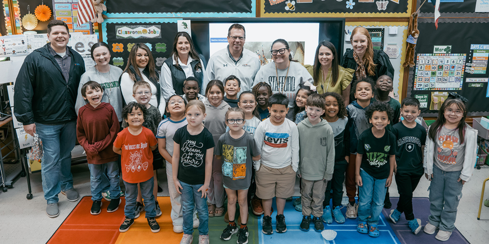 A photo of employee award winner Mallory Moser, her students, and other members of the AISD prize patrol