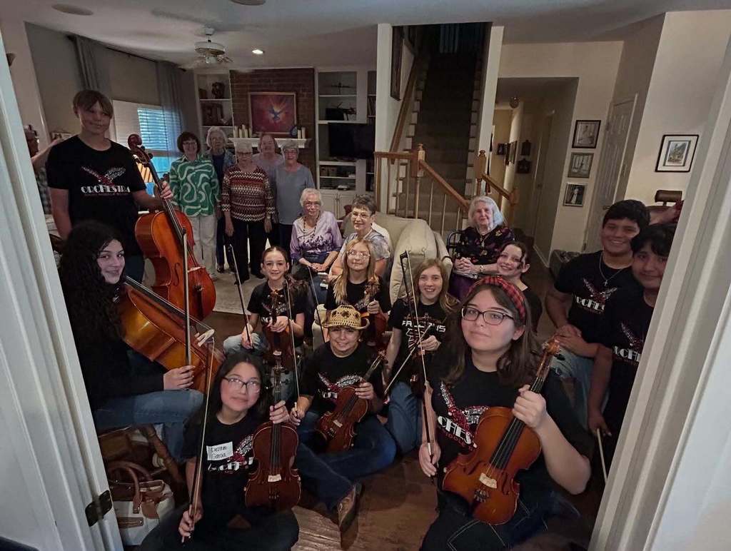 Orchestra students posing with members of the Harmony Club of Abilene.