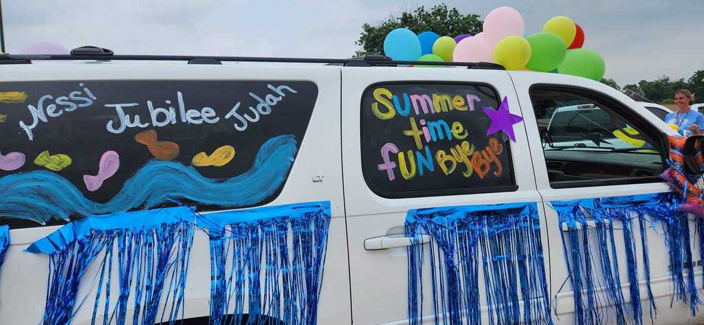 A decorated car with summer messages and student names
