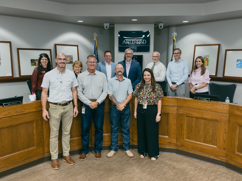A photo of David Roughton, Christina Dooley, facilities department leaders, and the board of trustees