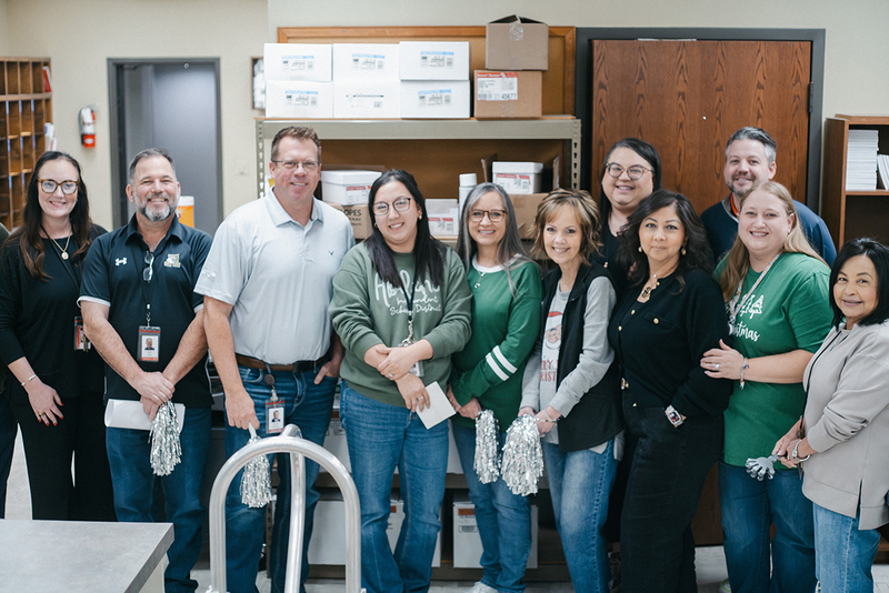 A group photo of Nicole Loepz, her co-workers, and district administrators