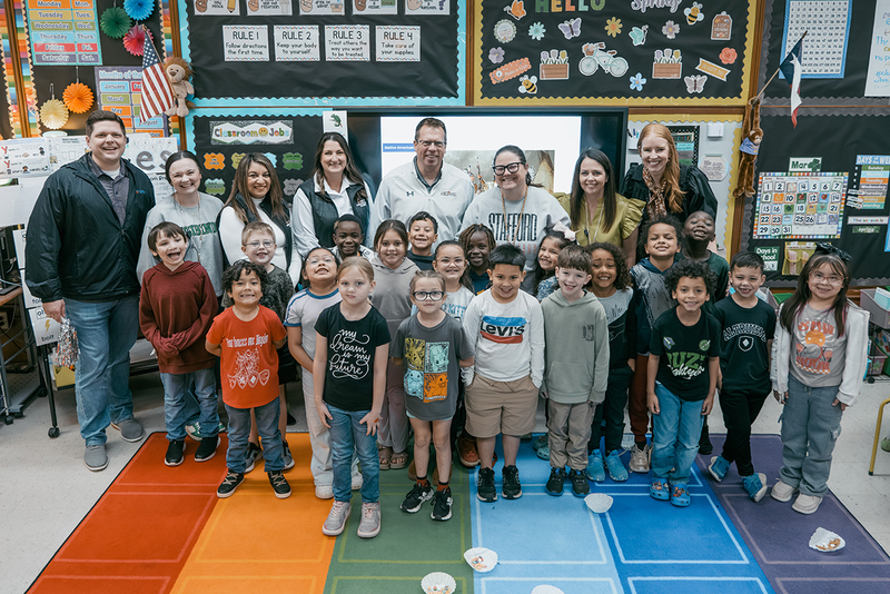 A photo of Mallory Moser, her class, and members of the prize patrol
