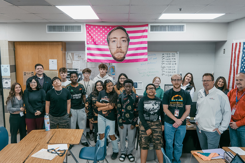 A photo of Mr. Moore, his class, and members of the prize patrol
