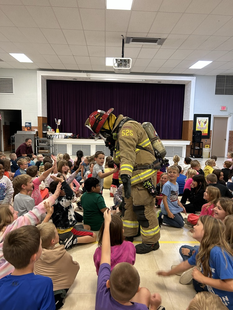 kids giving the firefighter a high 5