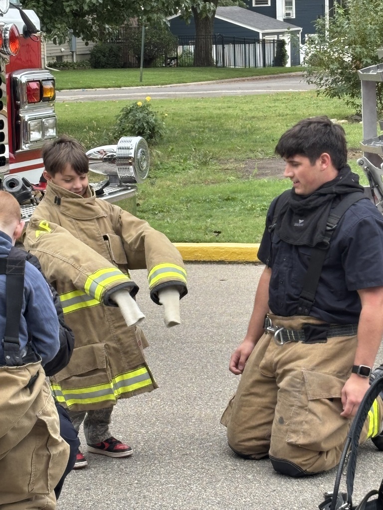 Child trying on a fire coat.