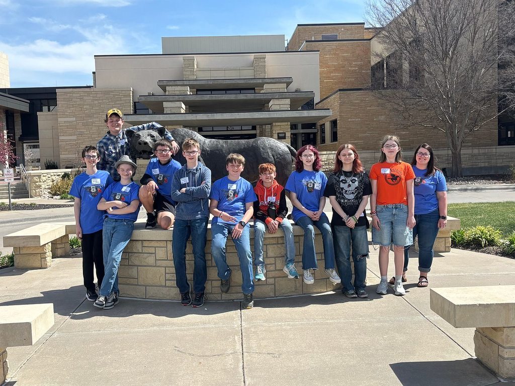 The AMS Robotics Team standing and sitting around the Ft. Hays mascot statue