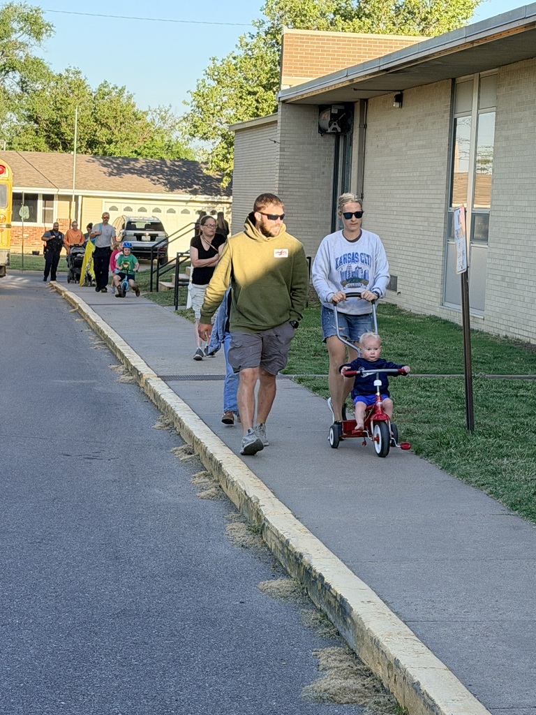 Families and volunteers walking and riding with students to school.