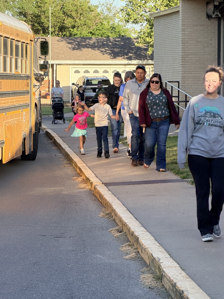 Families and volunteers walking and riding with students to school.