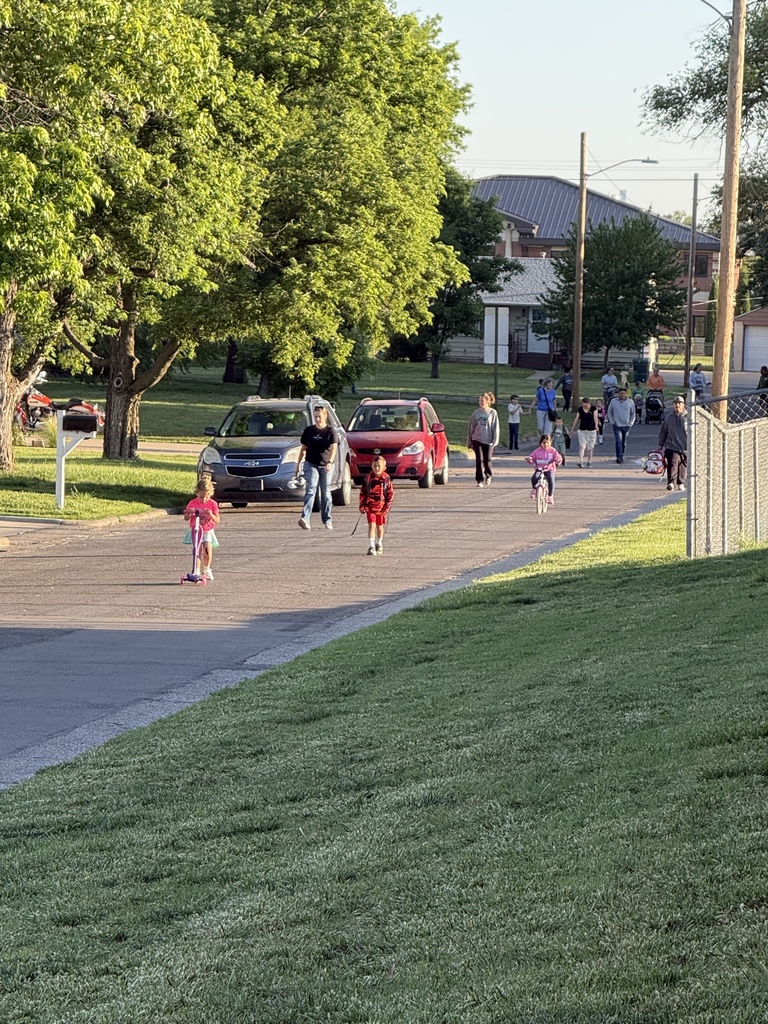 Families and volunteers walking and riding with students to school.