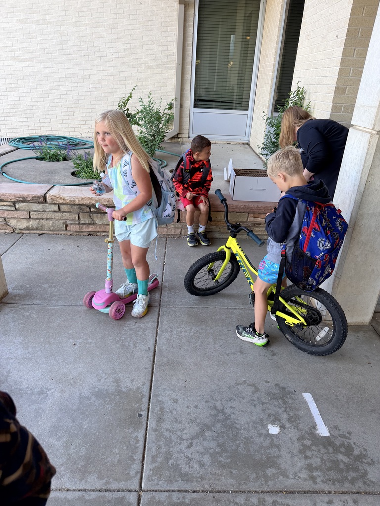 Kellie Olsen handing out water and bike bells to students.
