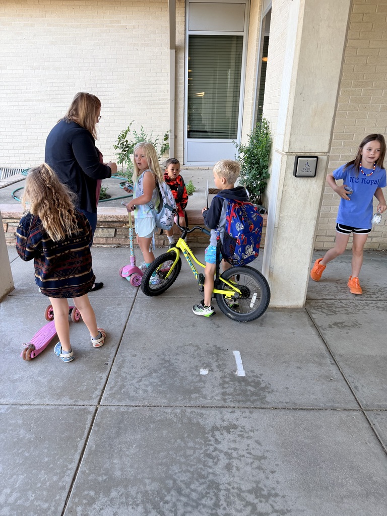 Kellie Olsen handing out water and bike bells to students.